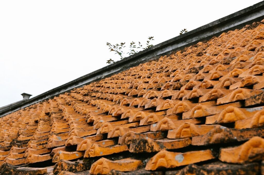 Close-up of an orange tiled roof showcasing traditional Asian architectural patterns.